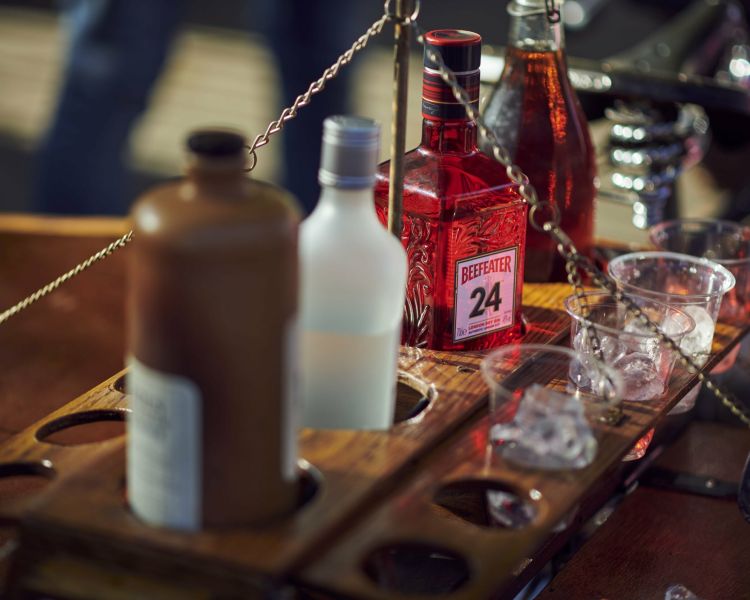 bottles of gin and gin glasses loaded on the back of a bicycle