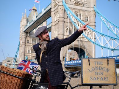 man with vintage bicycle in front of tower bridge on a london gin bike tour