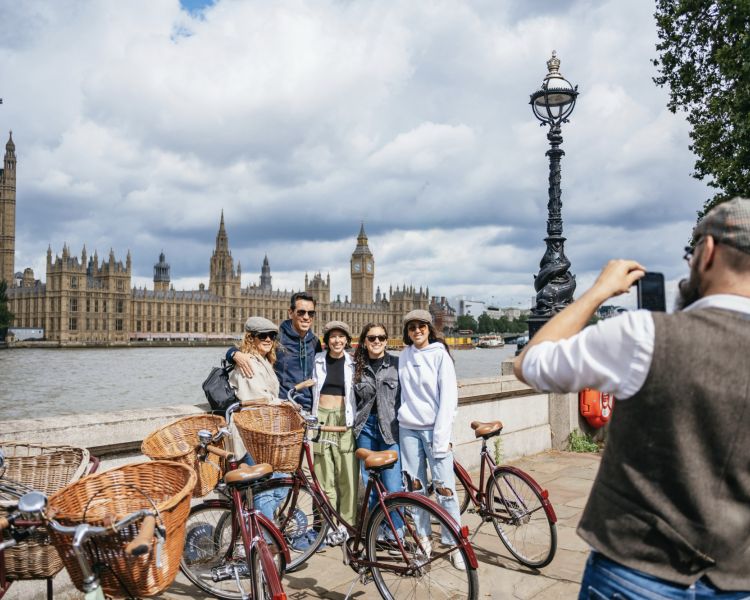 group of people having their photo taken standing in front of big ben on a london bike tour