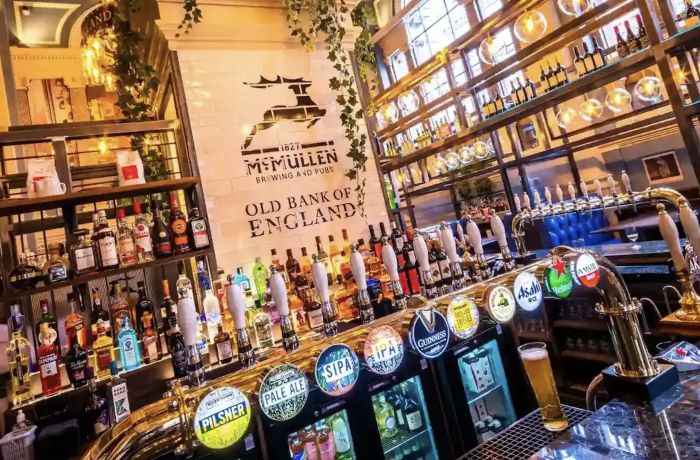 the bar inside an old pub in london showing all the beers and ales for sale seen on a secret london pub walking tour