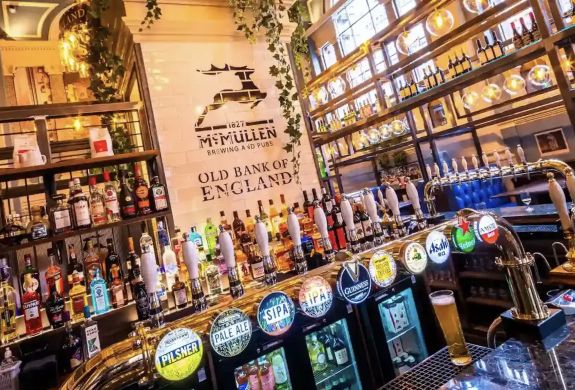 the bar inside an old pub in london showing all the beers and ales for sale seen on a secret london pub walking tour