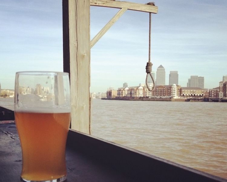 a pint of beer with the thames in the background and a hanging noose