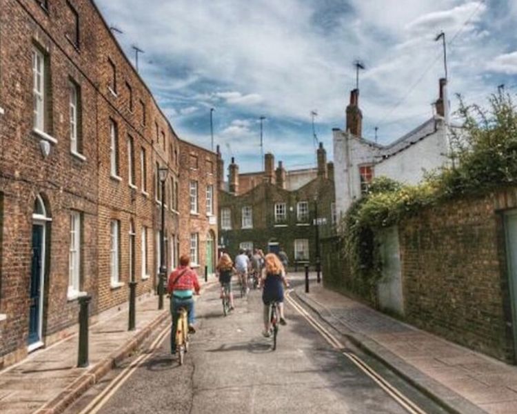 a group of people cycling down a london street on a london bike tour
