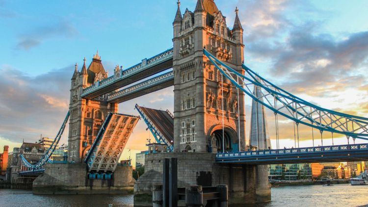 a woman taking a photo of tower bridge in London on a sightseeing visit