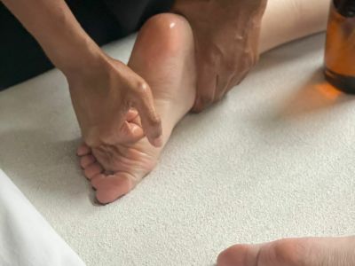 masseur massaging a clients feet as part of a reflexology treatment