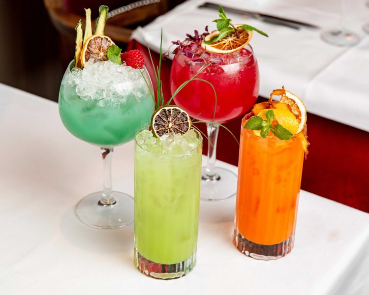 four cocktails on a table for a dining experience at marco pierre white's london steakhouse