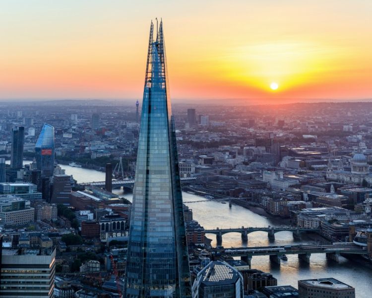 a view of the top of the shard at sunset against the london skyline