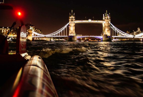 passengers enjoying a thames rocket speedboat experience in london at night with tower bridge lit up
