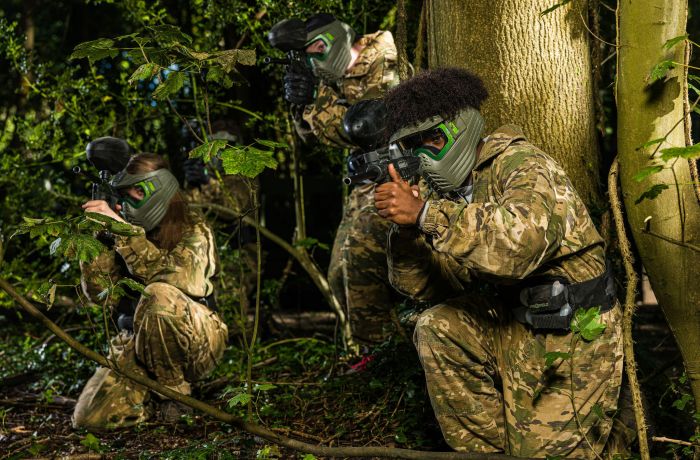 young people dressed in camouflage gear on a paint ball experience