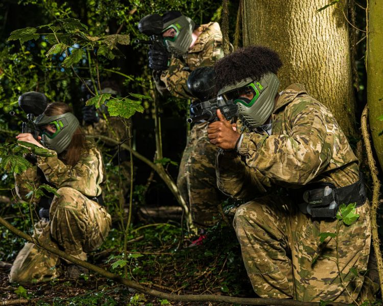 young people dressed in camouflage gear on a paint ball experience