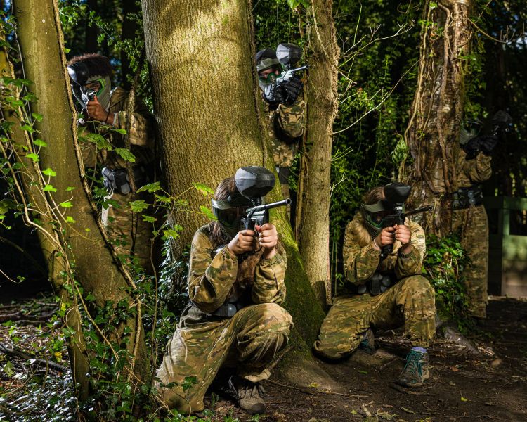young people dressed in camouflage gear ready for paint balling
