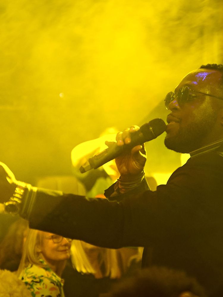 a man singing on stage at a motown dining experience in london
