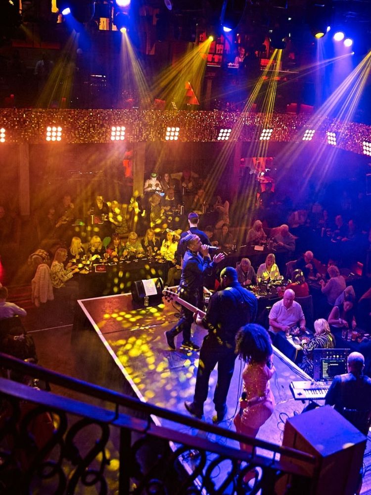 a live band on stage with diners looking on at a motown dining experience in london