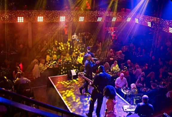 a live band on stage with diners looking on at a motown dining experience in london