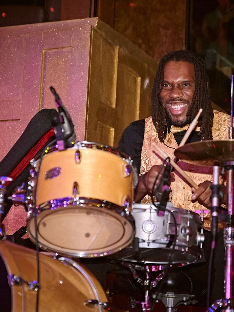 a man playing the drums on stage at a motown dining experience in london