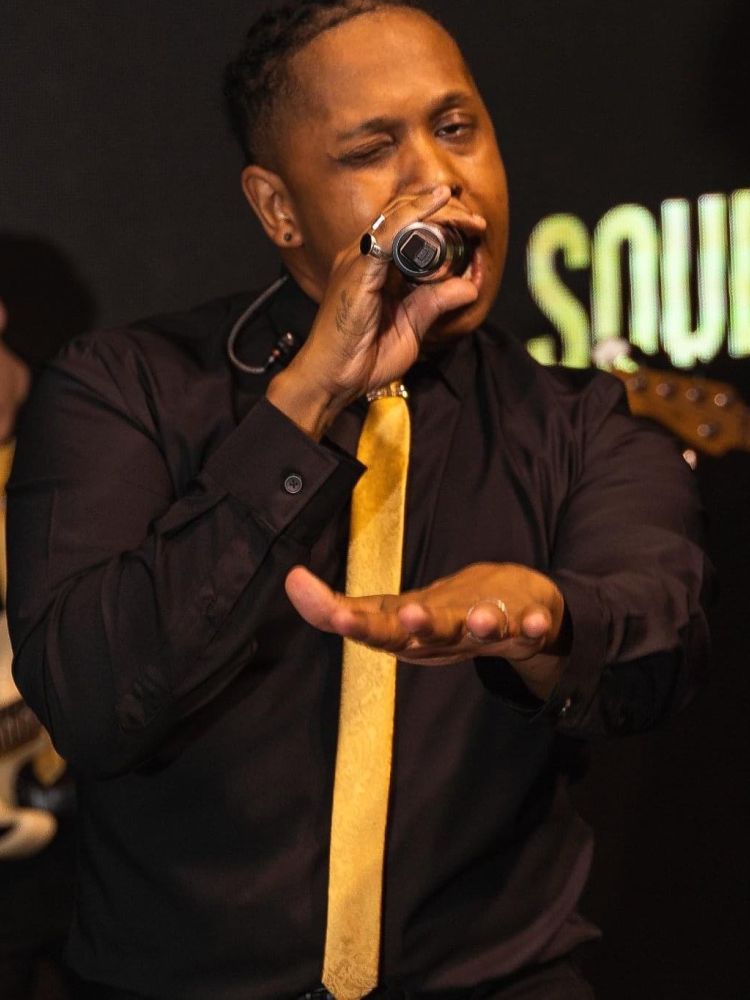 a man singing on stage at a motown dining experience in london