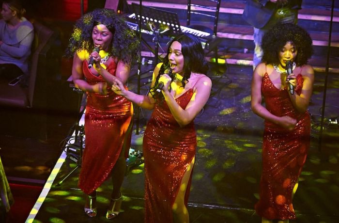 three singers on stage at a motown dining experience in london