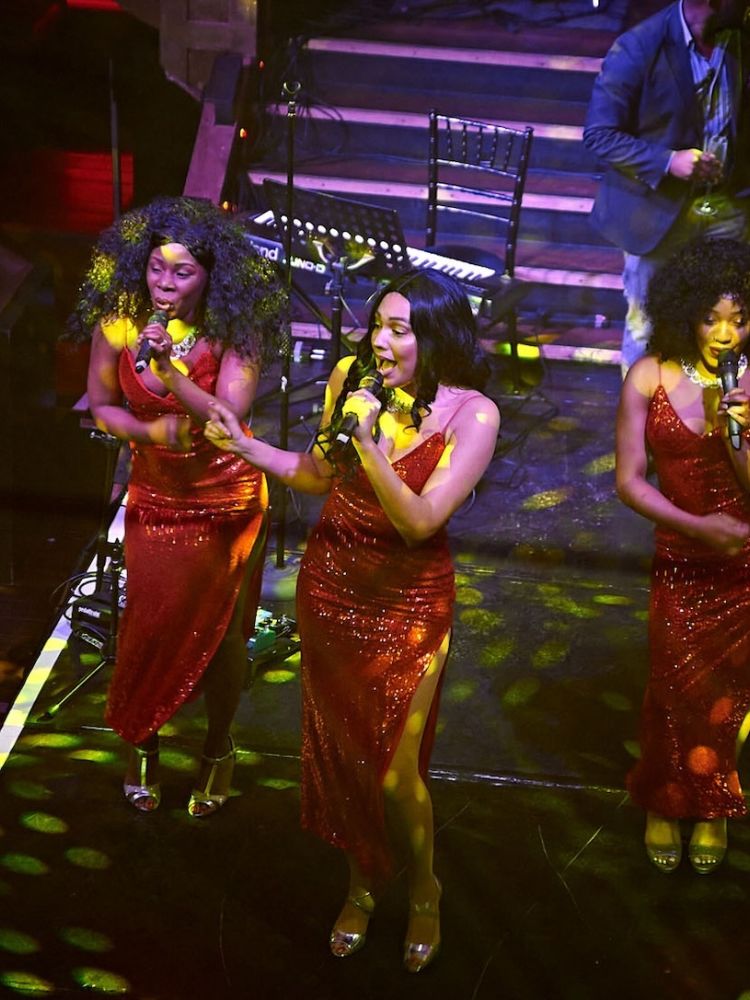 three singers on stage at a motown dining experience in london