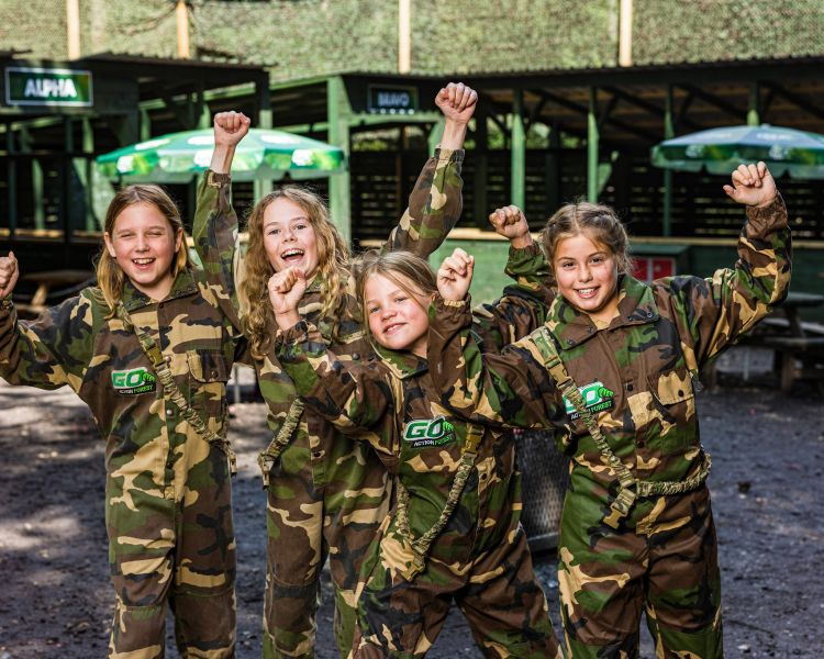 group of girls dressed in camouflage gear ready for forest laser tag