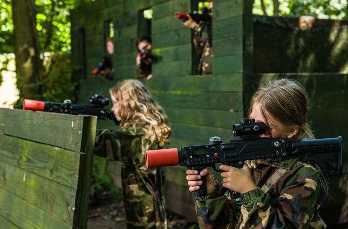 girls dressed in camouflage gear on a forest laser tag experience