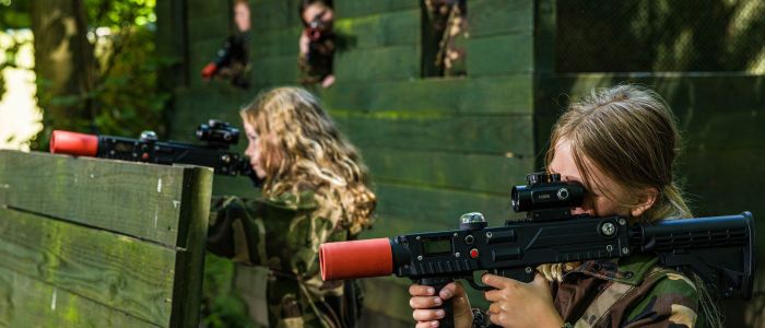 girls dressed in camouflage gear on a forest laser tag experience