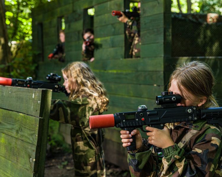 girls dressed in camouflage gear on a forest laser tag experience