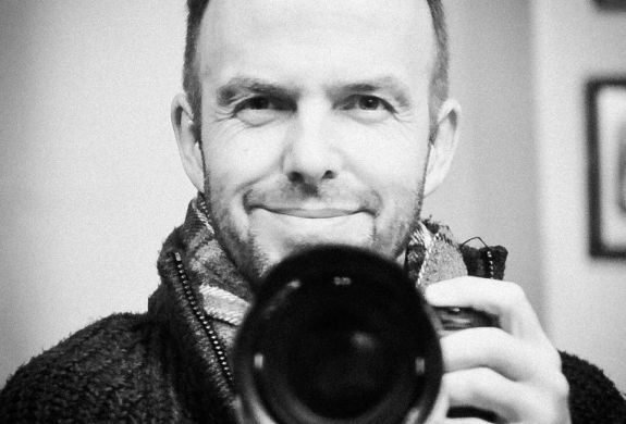 a black and white photo of professional photographer warren garrett holding a camera