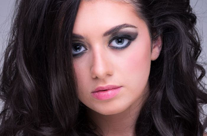 portrait shot of a young woman with glamourous makeup and bouncy hairstyle