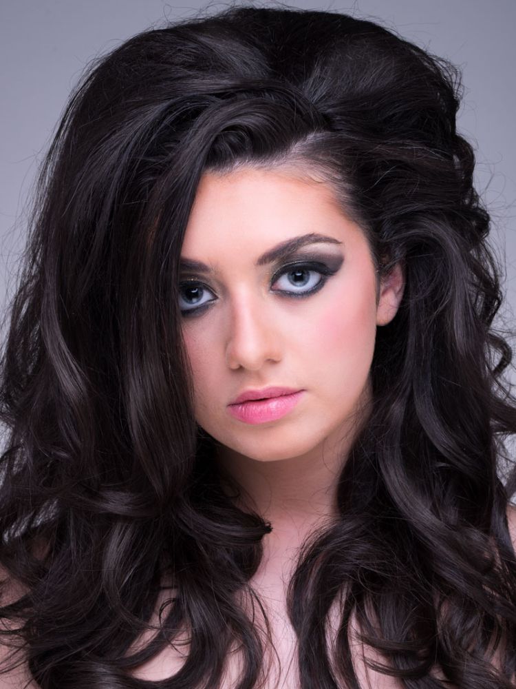 portrait shot of a young woman with glamourous makeup and bouncy hairstyle