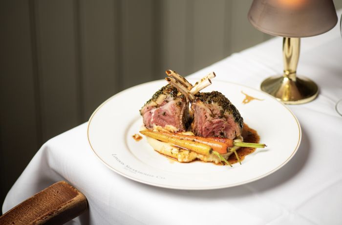 a meal of lamb chops on top of mashed potato and carrots at marco pierre white's london steakhouse company