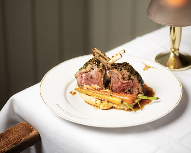 a meal of lamb chops on top of mashed potato and carrots at marco pierre white's london steakhouse company