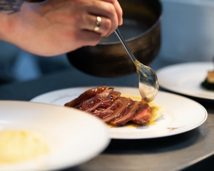 a meal being plated up at marco pierre white's london steakhouse company