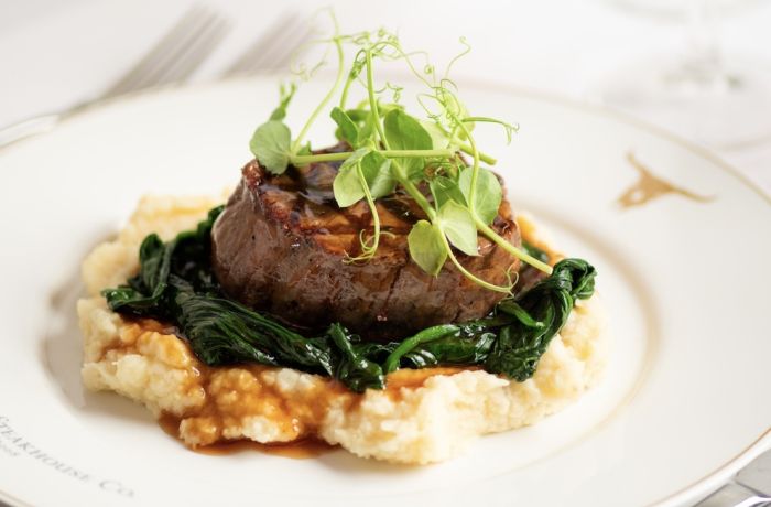 a meal at marco pierre white's london steakhouse company of steak on a layer of mashed potato and vegetables