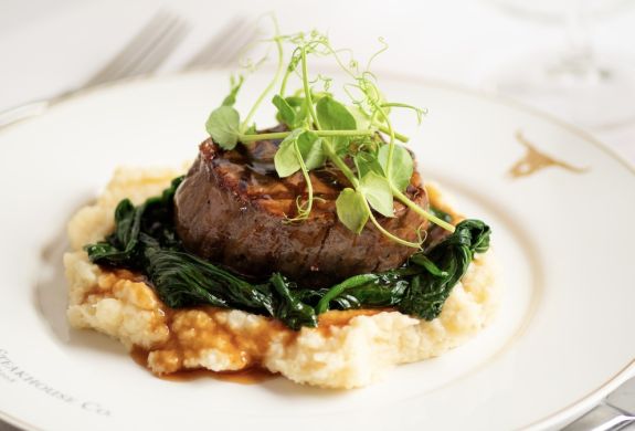 a meal at marco pierre white's london steakhouse company of steak on a layer of mashed potato and vegetables