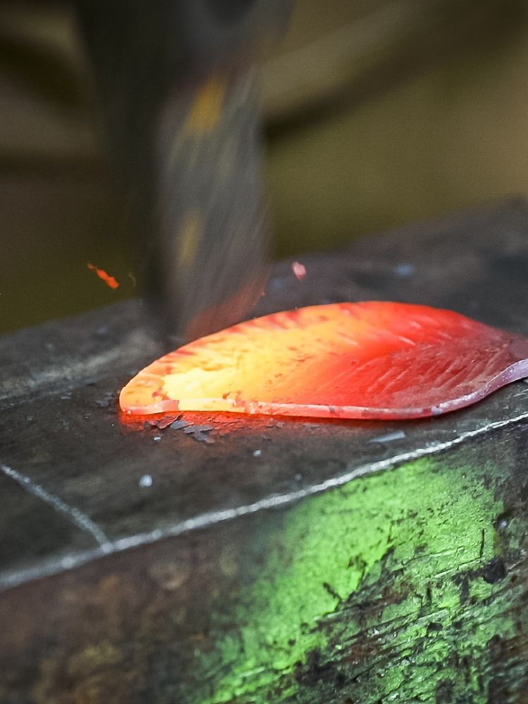 a leak hook being hammered into shape on a blacksmith experience