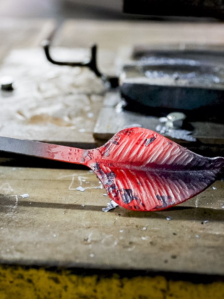 one of the leaves being made for the hooks on a coat rack on a blacksmith experience