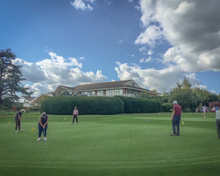 Golfers putting on a green