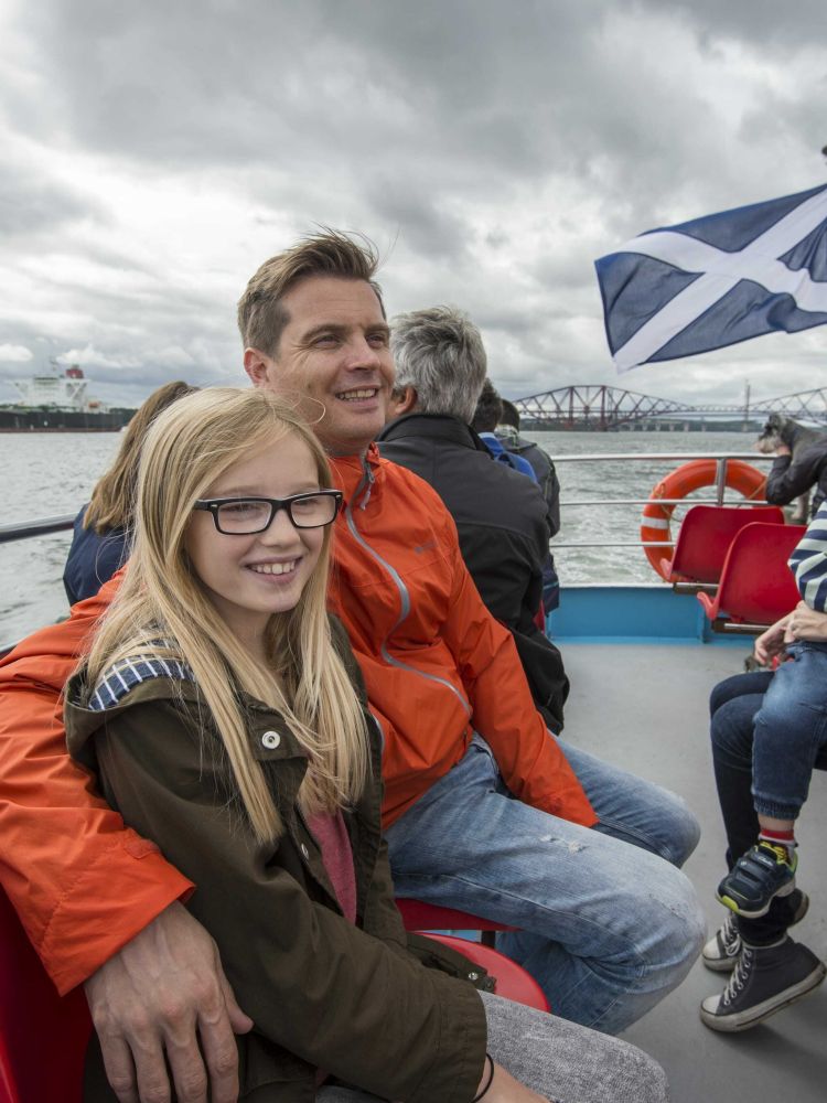 people sitting on the deck of a cruise boat on a daytime sightseeing cruise in scotland