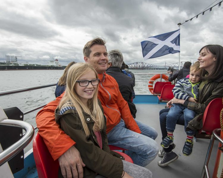 people sitting on the deck of a cruise boat on a daytime sightseeing cruise in scotland