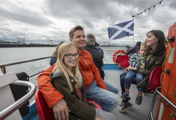 people sitting on the deck of a cruise boat on a daytime sightseeing cruise in scotland