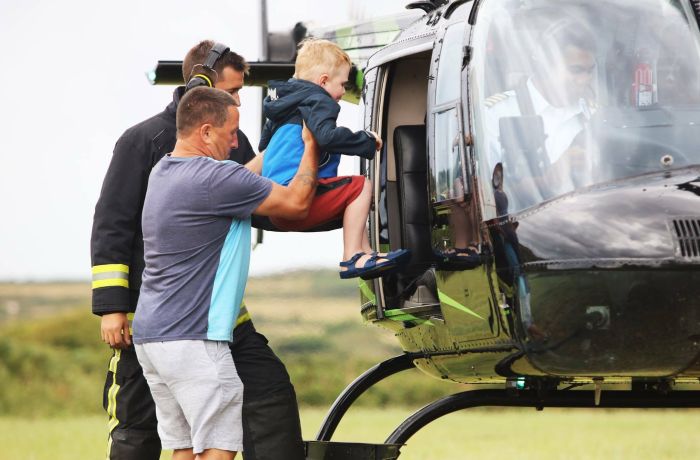 a man helping a child into a helicopter as part of a helicopter family experience