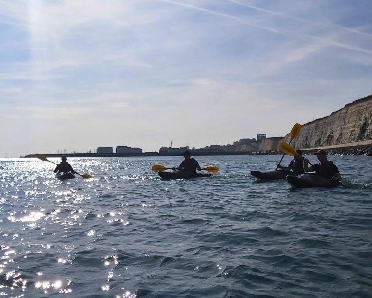 4 people kayaking in the sea
