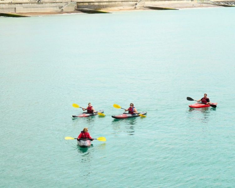 Group of 4 people kayaking in the sea