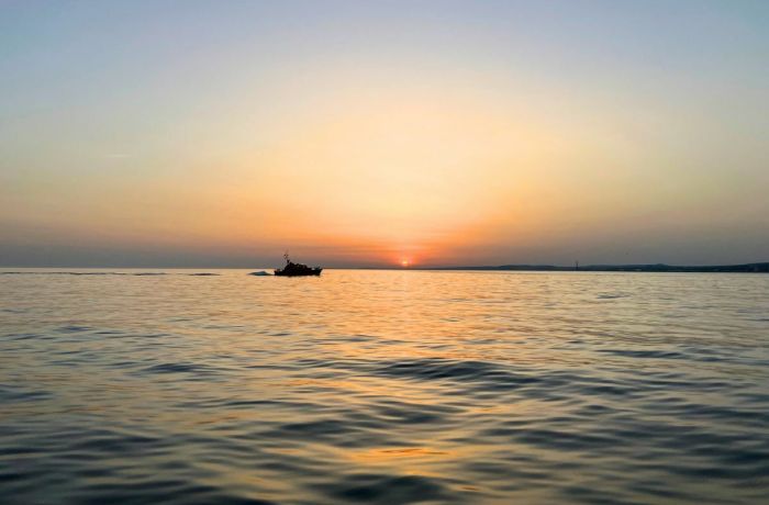 Boat in the sea with the sun setting