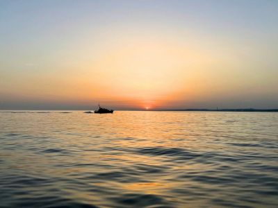 Boat in the sea with the sun setting