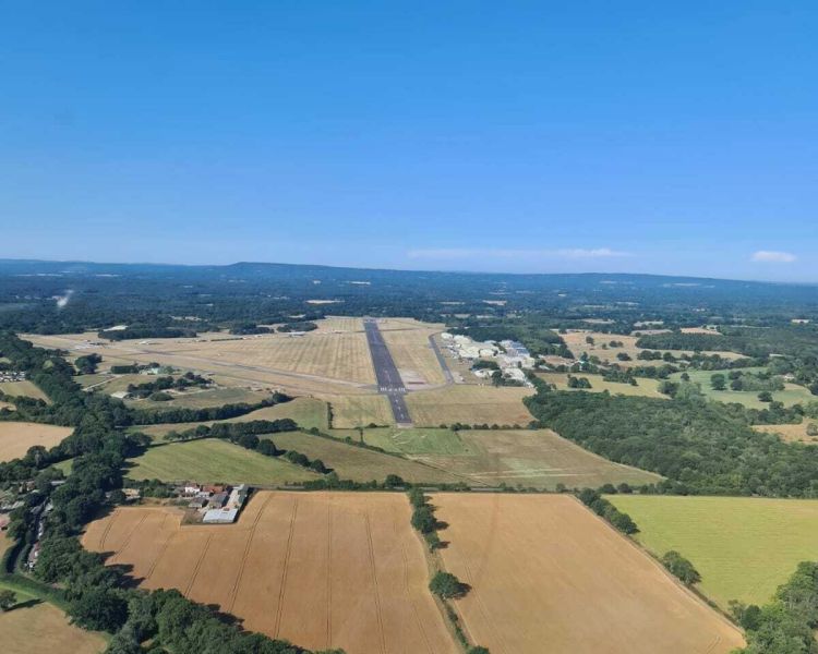 the views from a helicopter flying over countryside as part of a helicopter flying lesson experience