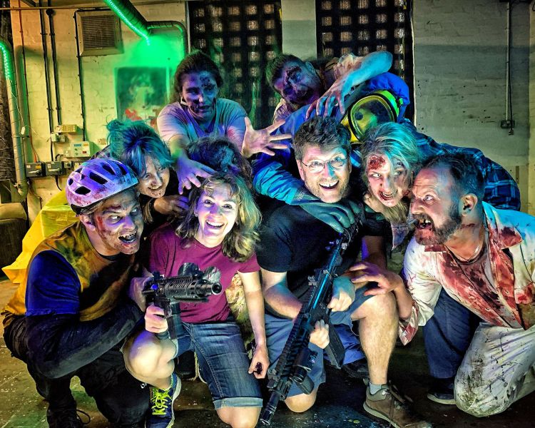 man and woman surrounded by zombies as part of a zombie immersive day out