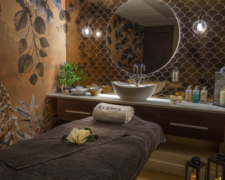 A spa treatment room set up with elemis products behind the bed at the spa hotel dunston hall in norfolk
