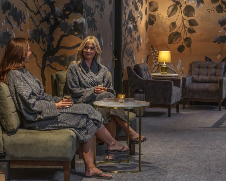 Two ladies in bath robes chatting in the relaxation area of the spa hotel dunston hall in norfolk