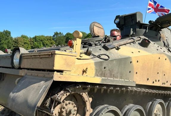 a man driving a tank on tank driving experience